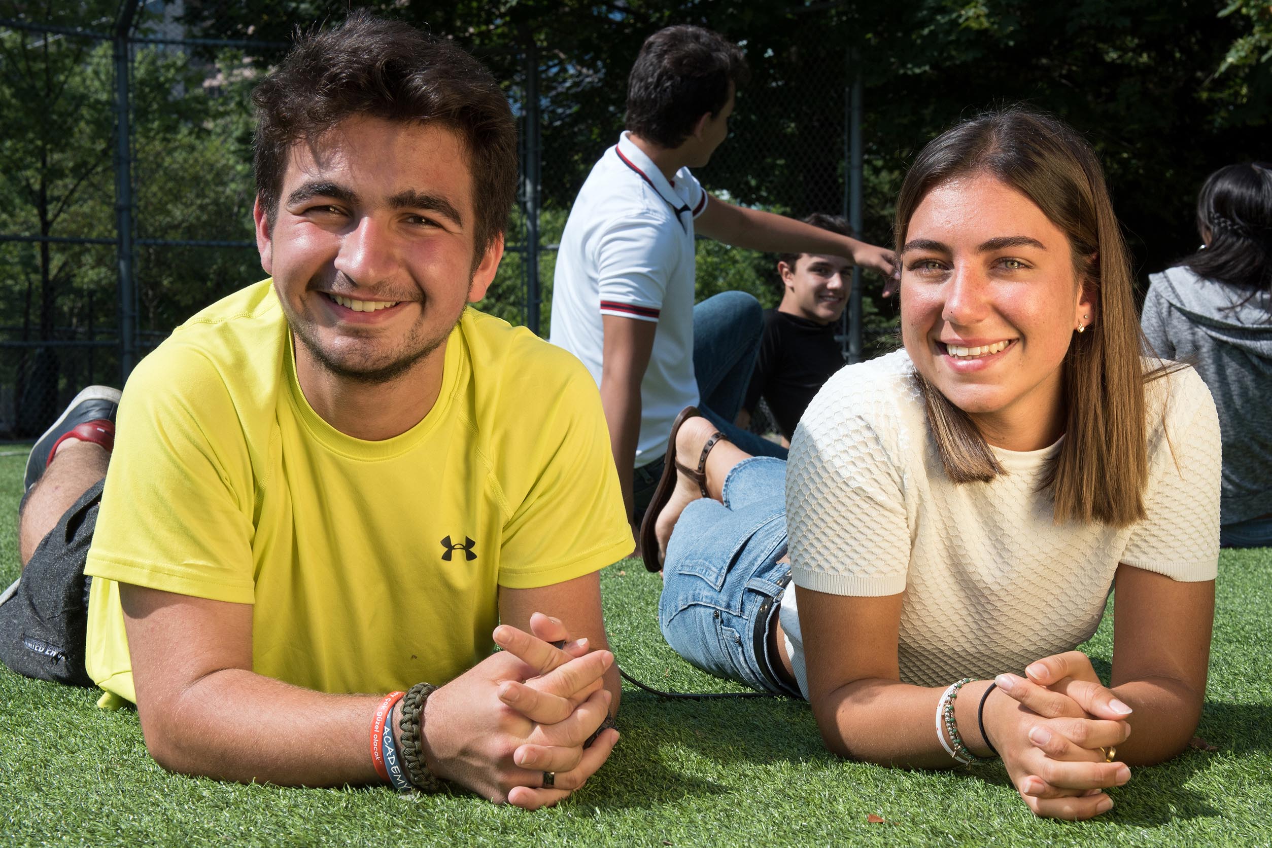 Two students smiling with students in the background Open Gallery